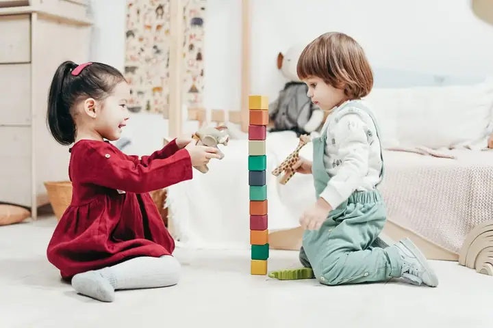 Two toddlers playing side by side at playgroup