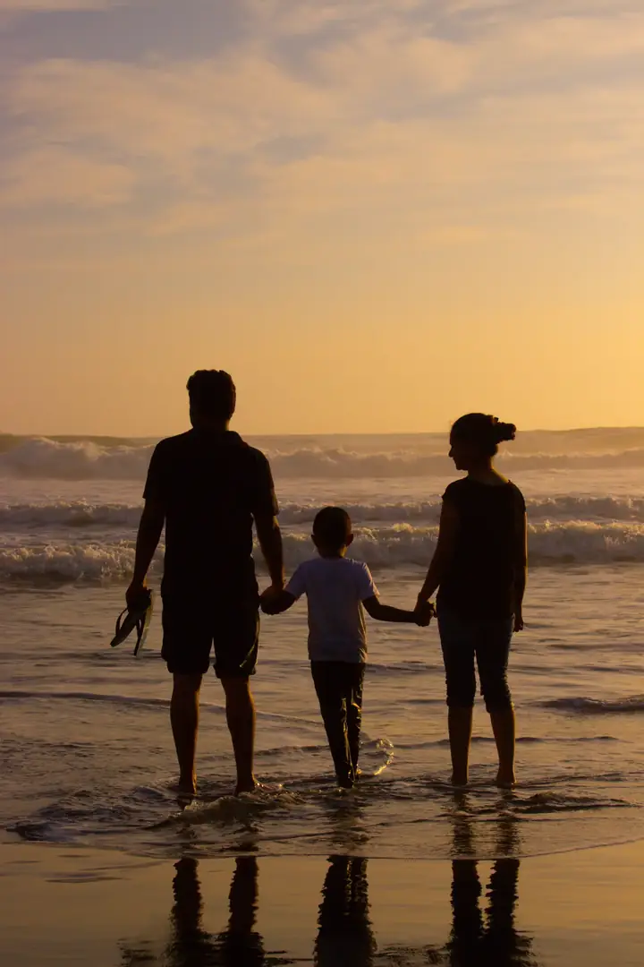 Parents walking together at sunset, hands joined